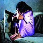 young sad and depressed Asian Korean woman at home sofa couch cr